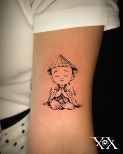 Vietnamese Tattoo of a peaceful little monk wearing a traditional conical hat.