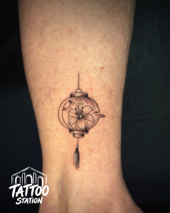 Fine Line Tattoo featuring a traditional Hoi An lantern with a lily flower by Tattoo Station Hoi An