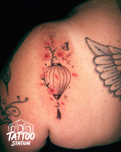 Fine Line Tattoo of a Hoi An lantern with cherry blossoms and butterfly by Tattoo Station Hoi An